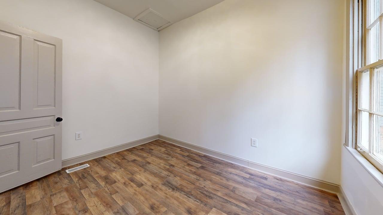 860 Stokes Street Danville, VA 24541 - Photo 27 of 32 an empty room with wooden floor and windows