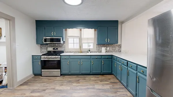 a kitchen with stainless steel appliances granite countertop a stove a sink and a microwave