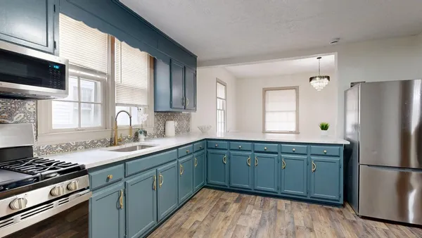 a kitchen with a sink cabinets stainless steel appliances and a window