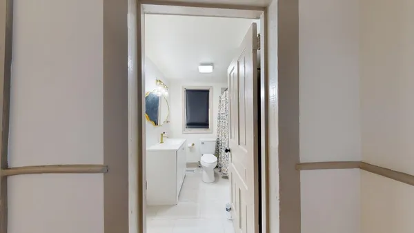 a view of a hallway with toilet and a door