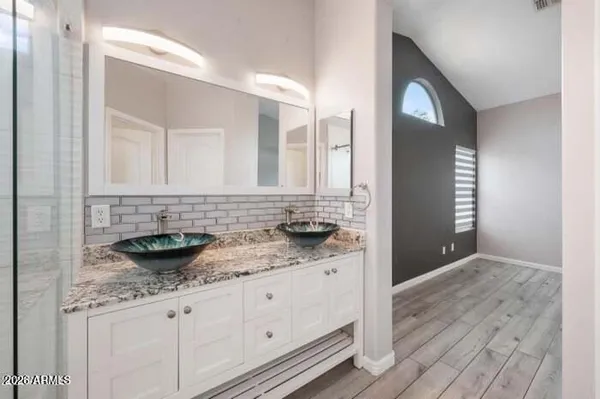 a bathroom with a granite countertop double vanity sink and mirror