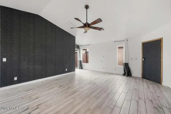 a view of a livingroom with a ceiling fan and wooden floor