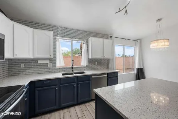 a kitchen with a sink a center island cabinets and a window