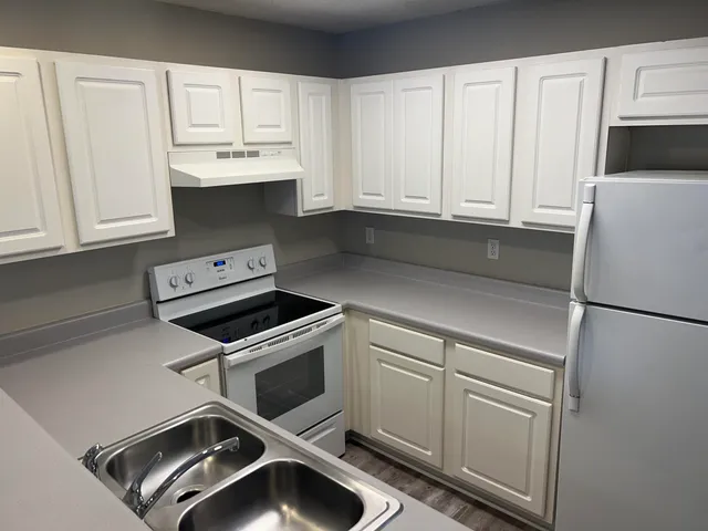 a kitchen with a refrigerator sink and cabinets