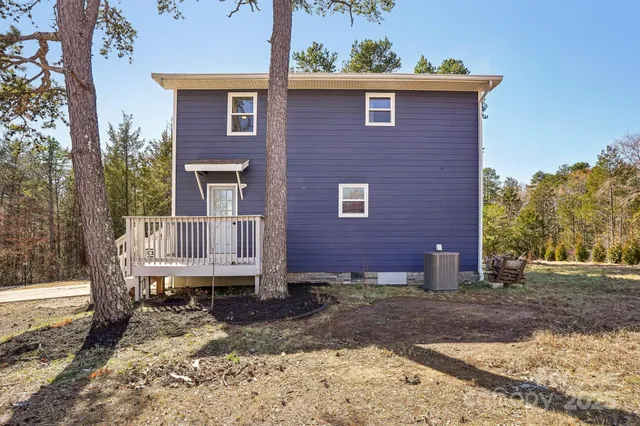 a view of a brick house with a yard and large tree