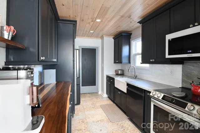 a kitchen with stainless steel appliances granite countertop a stove refrigerator and microwave