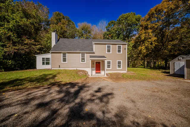 a view of a yard in front of a house with a large tree
