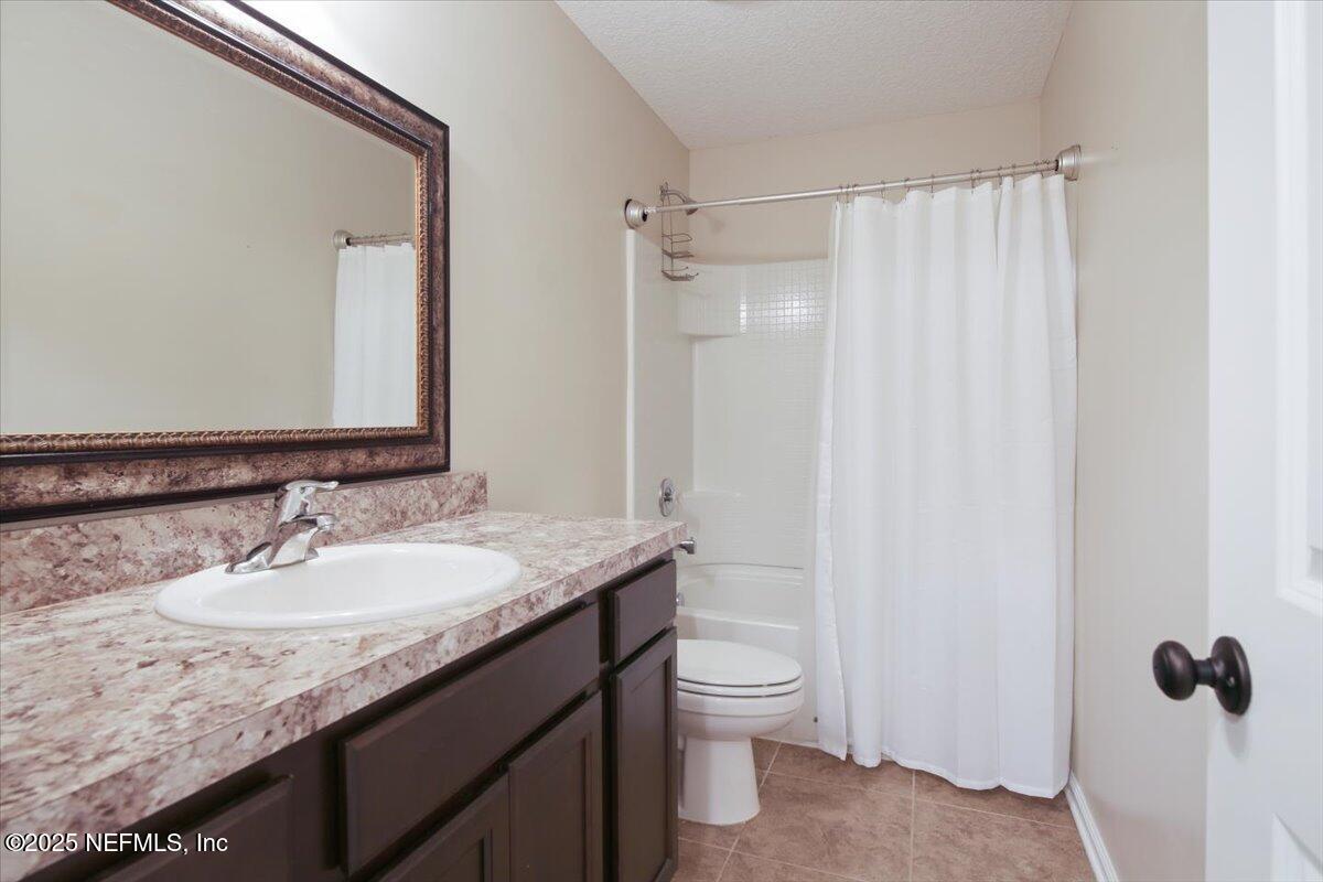 4182 Quiet Crk Loop Middleburg, FL 32068 - Photo 15 of 30 a bathroom with a granite countertop sink toilet and shower