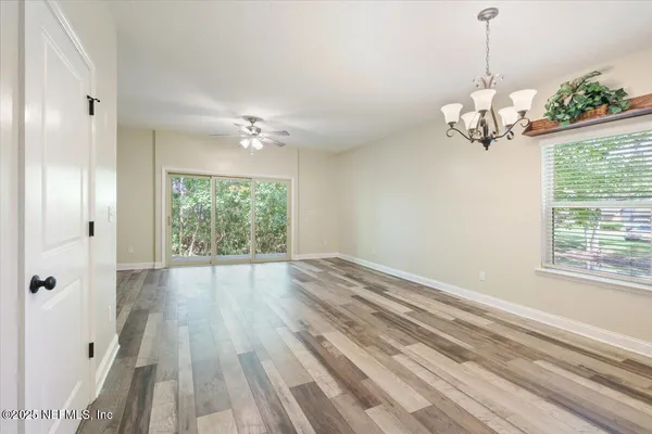 a view of a room with a chandelier fan and windows