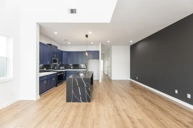 a kitchen with granite countertop a sink a counter top space stainless steel appliances and cabinets
