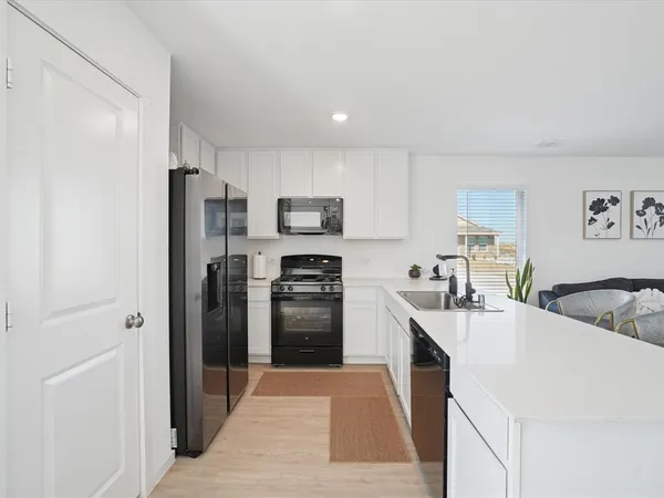 a kitchen with stainless steel appliances a refrigerator stove microwave and sink