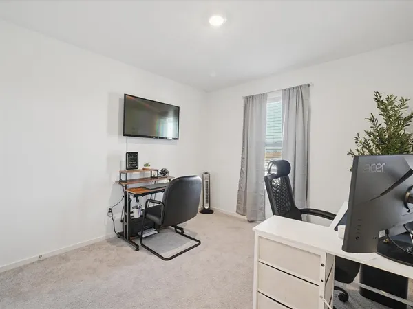 a view of a workspace with furniture and a window