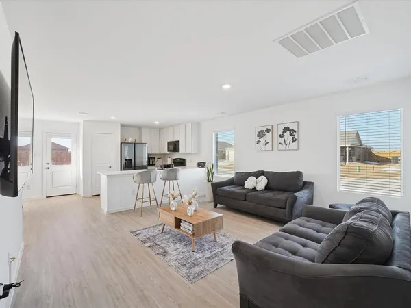 a living room with furniture and a wooden floor