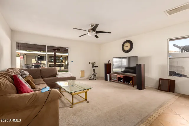 a living room with furniture a clock and a flat screen tv
