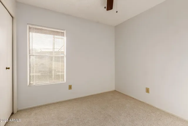 an empty room with cabinet and ceiling fan