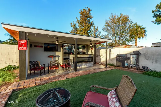 a view of a patio with table and chairs potted plants and large tree