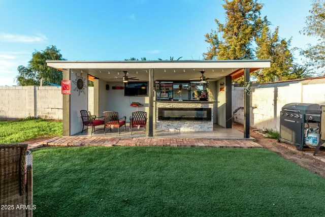 a living room with furniture a flat screen tv and floor to ceiling window