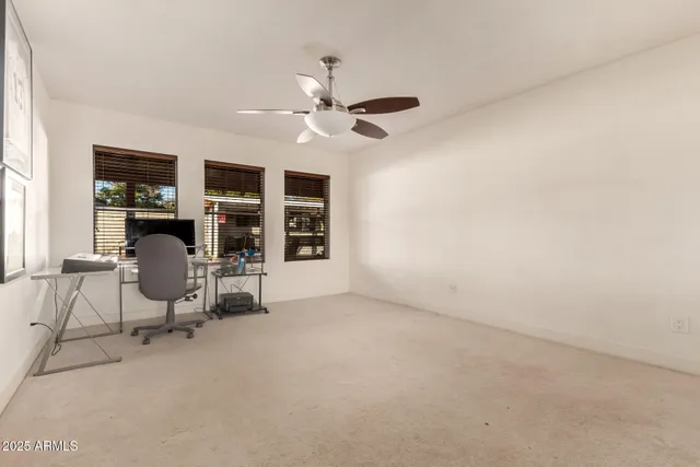 a living room with furniture and a ceiling fan