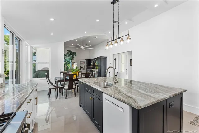 a view of a dining room and livingroom furniture wooden floor a rug a flat screen tv and a chandelier