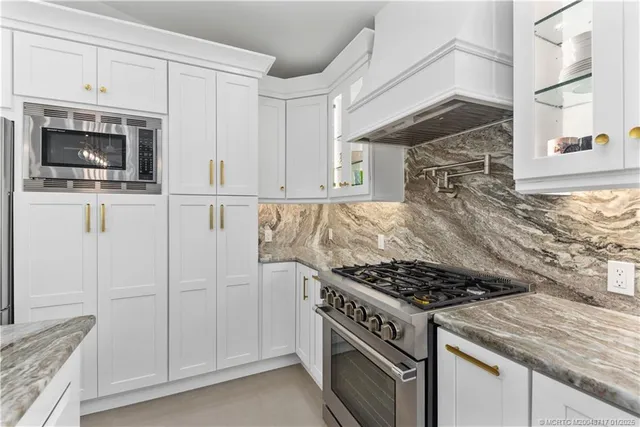 a kitchen with white cabinets and appliances