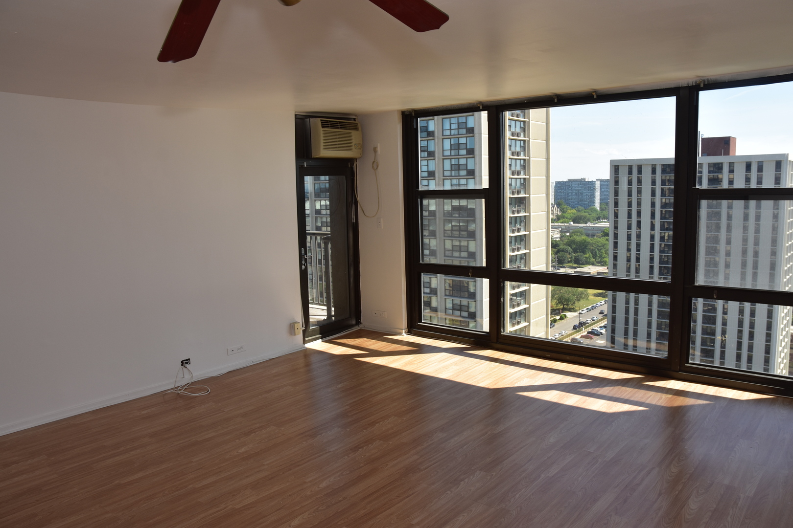 2605 South Indiana Avenue, Unit 2008 Chicago, IL 60616 - Photo 5 of 25 a view of an empty room with wooden floor and a window