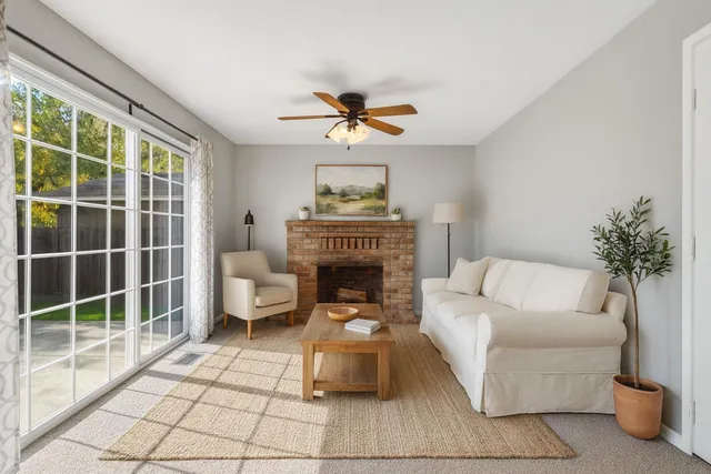 a living room with furniture a fireplace and a chandelier