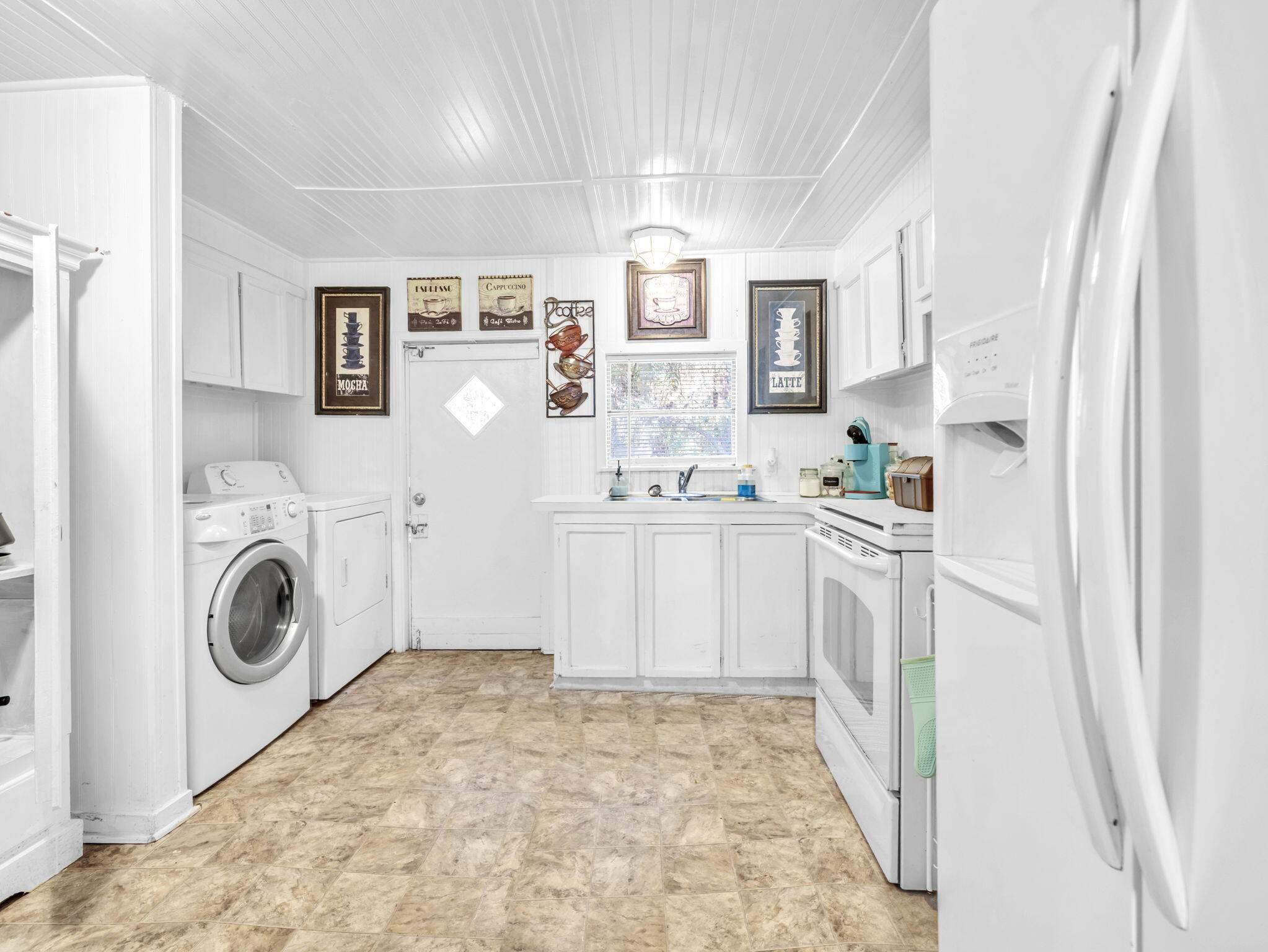 9028 Larker Woods Road Navarre, FL 32566 - Photo 11 of 36 a kitchen with white cabinets and white appliances