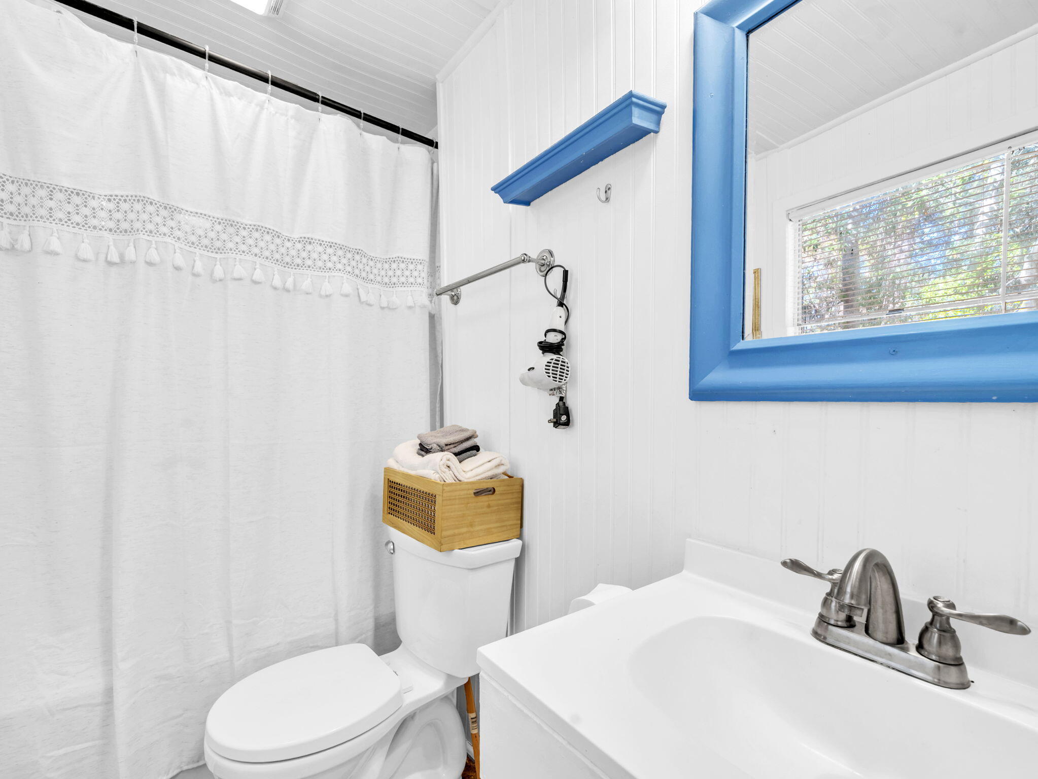 9028 Larker Woods Road Navarre, FL 32566 - Photo 24 of 36 a bathroom with a sink a toilet and shower curtain