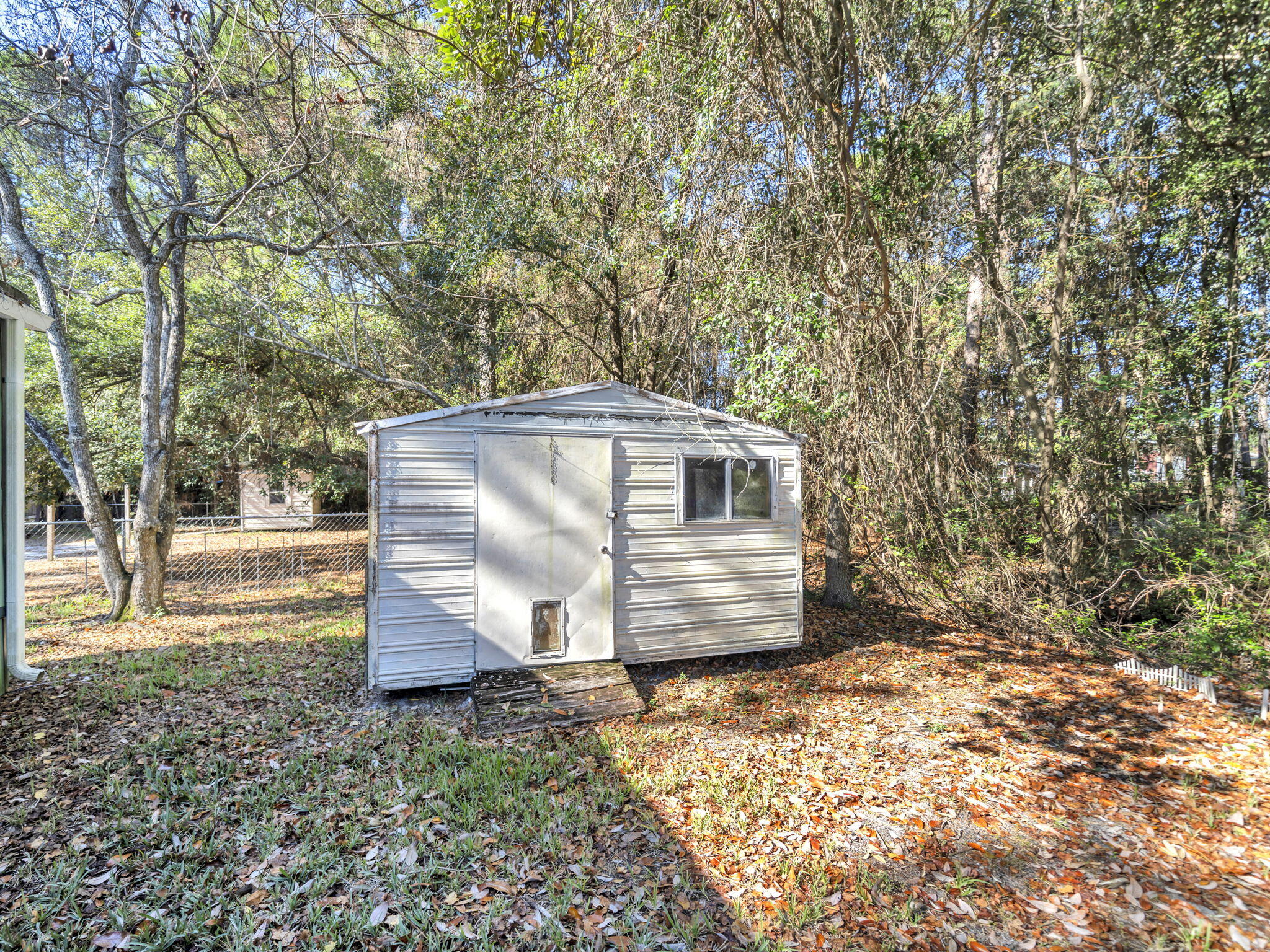 9028 Larker Woods Road Navarre, FL 32566 - Photo 34 of 36 a view of backyard with wooden fence and large trees