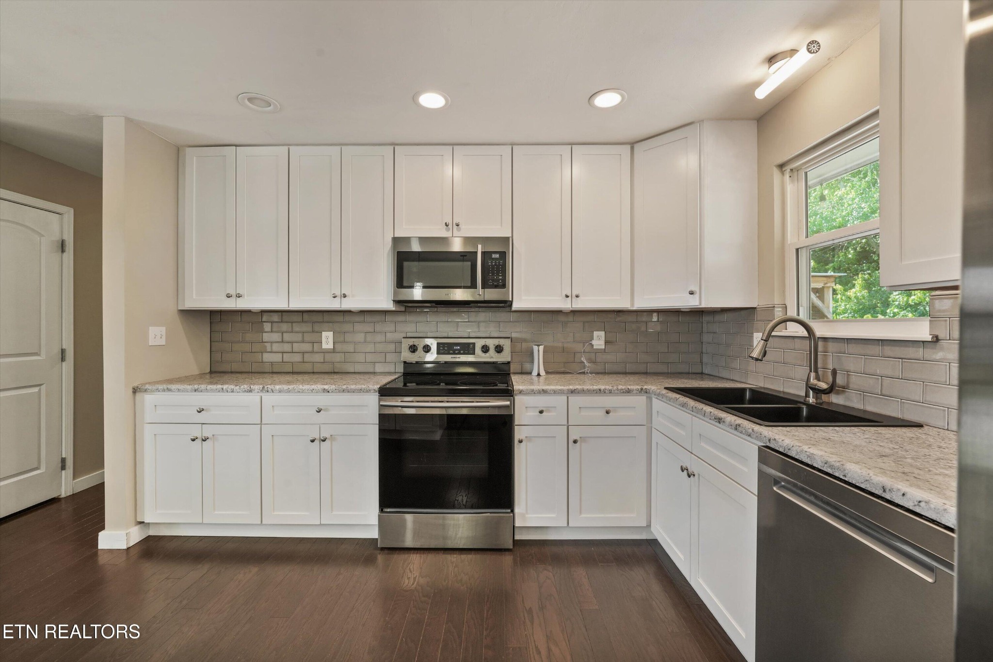 7613 Fall Wind Court Powell, TN 37849 - Photo 9 of 38 a kitchen with stainless steel appliances granite countertop a stove a sink and a microwave