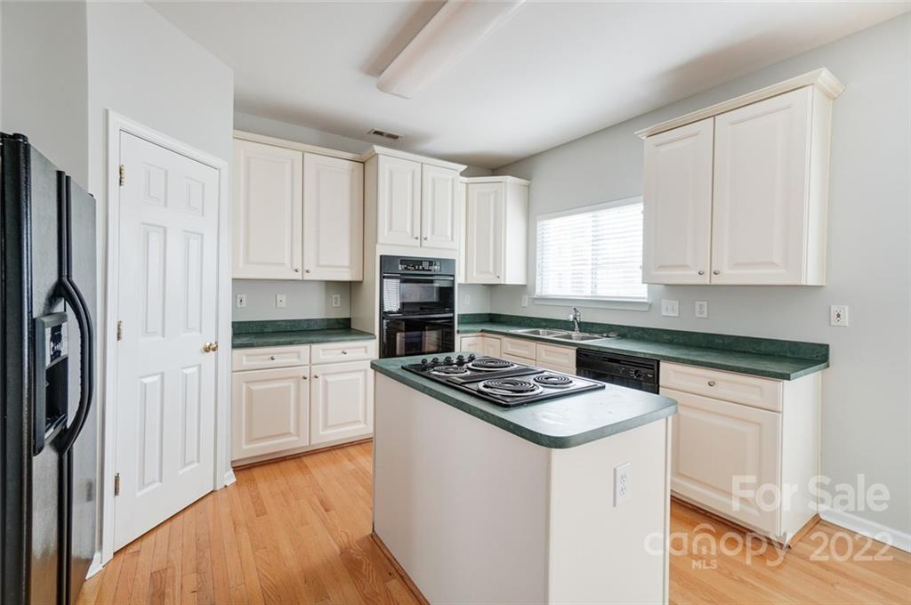 144 Rock Ridge Lane Mount Holly, NC 28120 - Photo 12 of 48 a kitchen with stainless steel appliances granite countertop a stove top oven a sink a refrigerator white cabinets and wooden floor