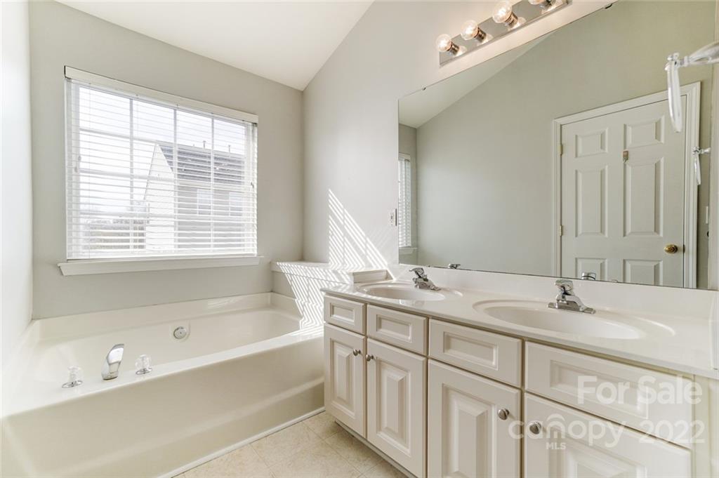 144 Rock Ridge Lane Mount Holly, NC 28120 - Photo 28 of 48 a bathroom with a tub sink and mirror