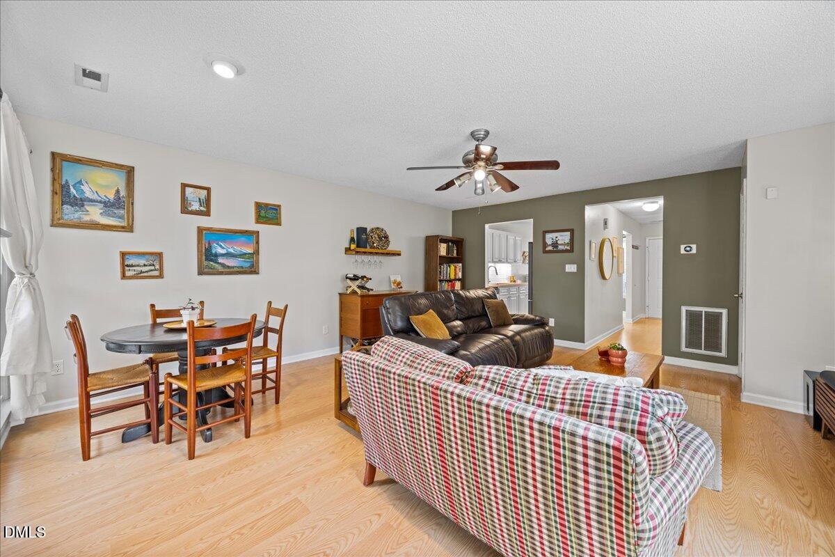 501 Darby Glen Lane Durham, NC 27713 - Photo 13 of 25 a living room with furniture kitchen view and a wooden floor