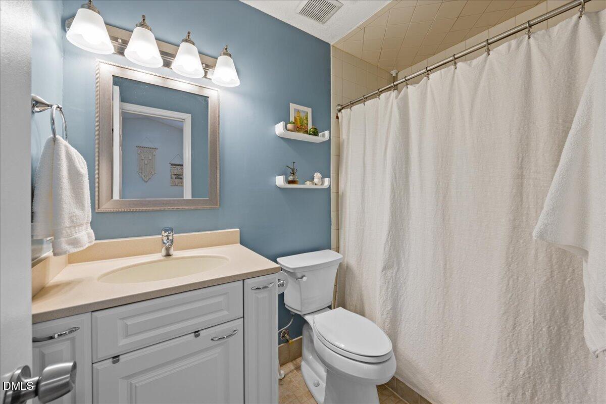 501 Darby Glen Lane Durham, NC 27713 - Photo 18 of 25 a bathroom with a sink a toilet and a mirror