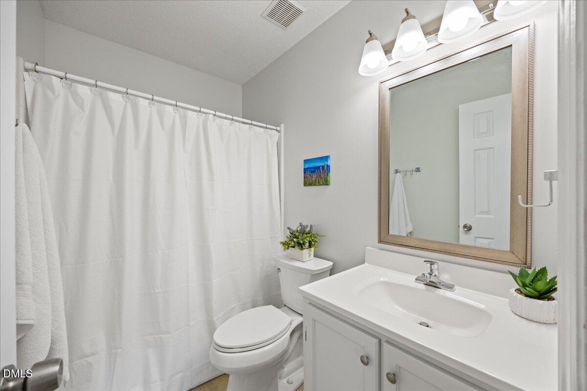 501 Darby Glen Lane Durham, NC 27713 - Photo 20 of 25 a bathroom with a sink a toilet and a mirror