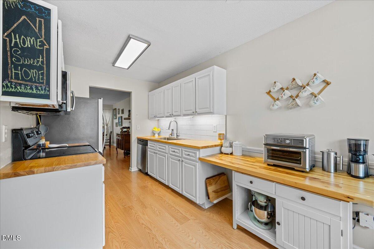 501 Darby Glen Lane Durham, NC 27713 - Photo 7 of 25 a kitchen with stainless steel appliances a stove a sink and a refrigerator