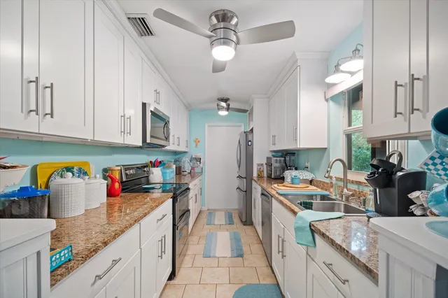 a kitchen with stainless steel appliances granite countertop a sink dishwasher and a refrigerator