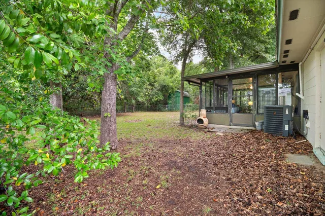 a view of a house with backyard and a tree