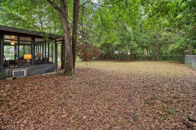 a front view of a house with a garden and trees