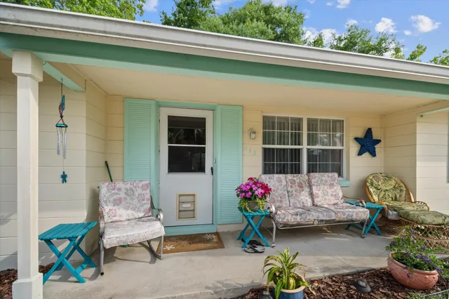 a front view of a house with outdoor seating and flowers