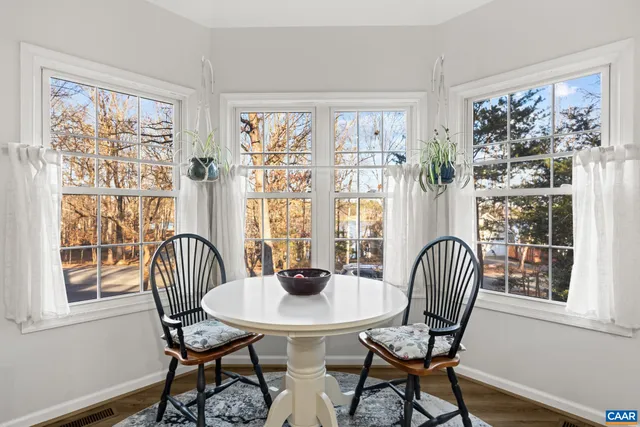 a view of a patio with table and chairs with wooden floor and fence