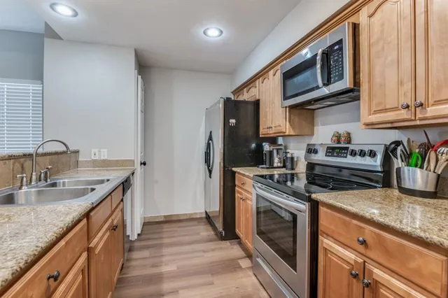 a kitchen with stainless steel appliances granite countertop a sink stove and cabinets