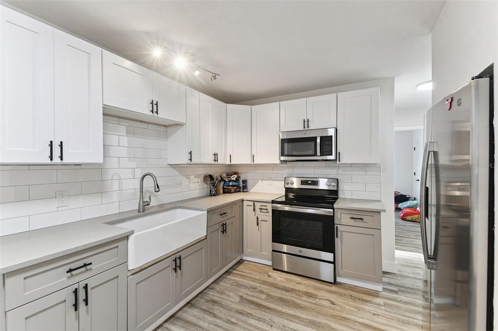 4706 Catherine Street New Port Richey, FL 34652 - Photo 14 of 45 a kitchen with stainless steel appliances granite countertop a sink stove and refrigerator