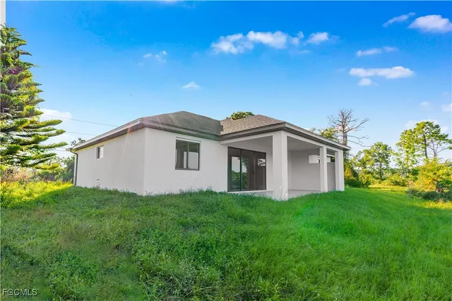 a white house with a small yard and a big yard