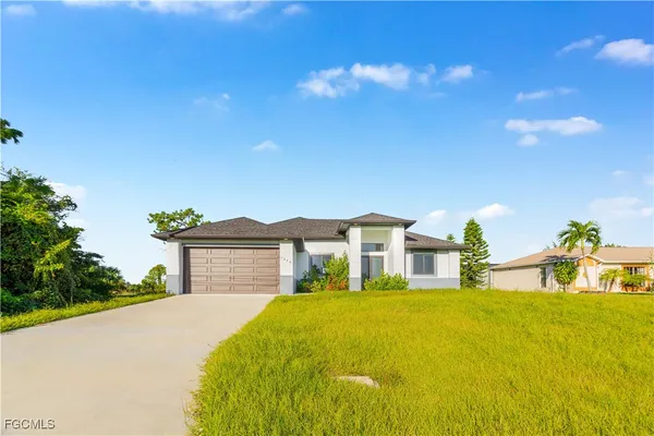 a front view of a house with a garden and yard