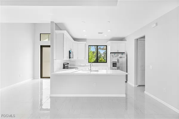 a large white kitchen with a large window