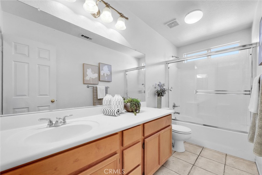 12351 Mesa Grove Drive Riverside, CA 92503 - Photo 14 of 25 a bathroom with a double vanity sink toilet and shower