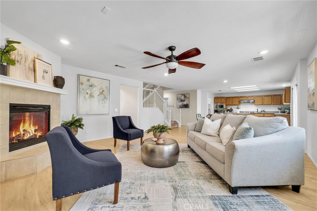 12351 Mesa Grove Drive Riverside, CA 92503 - Photo 5 of 25 a living room with furniture a ceiling fan and a fireplace