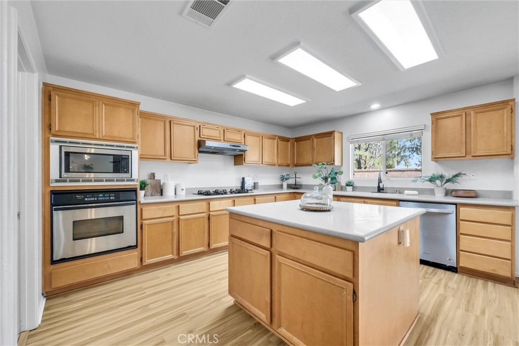 12351 Mesa Grove Drive Riverside, CA 92503 - Photo 7 of 25 a kitchen with white cabinets appliances and a window