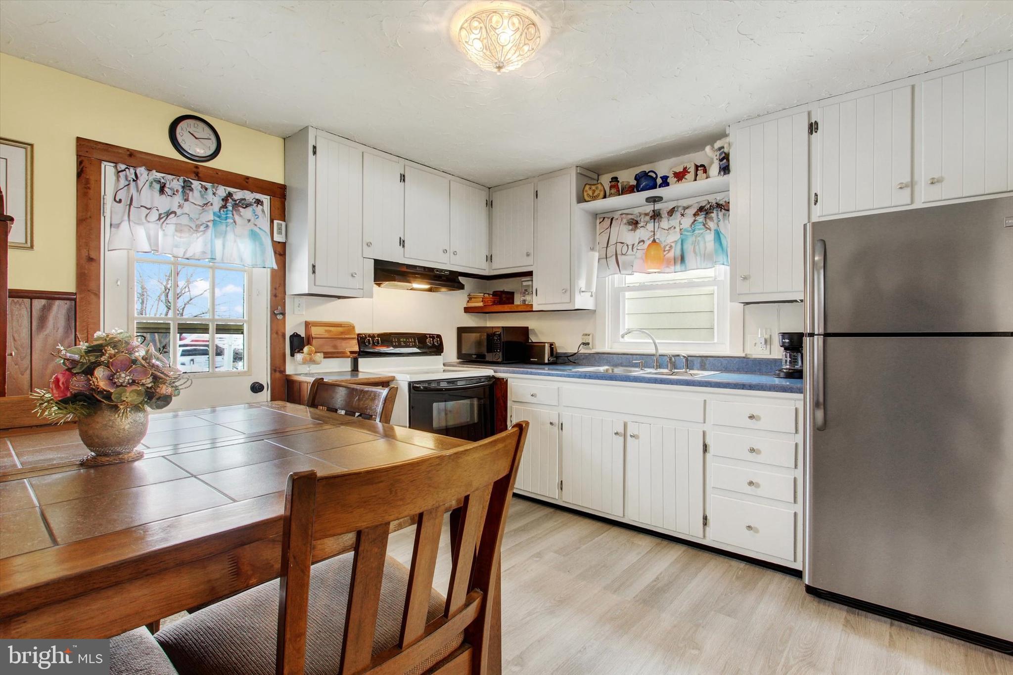 371 Maple Avenue Hanover, PA 17331 - Photo 10 of 24 a kitchen with stainless steel appliances granite countertop a refrigerator a stove a sink dishwasher and white cabinets with wooden floor
